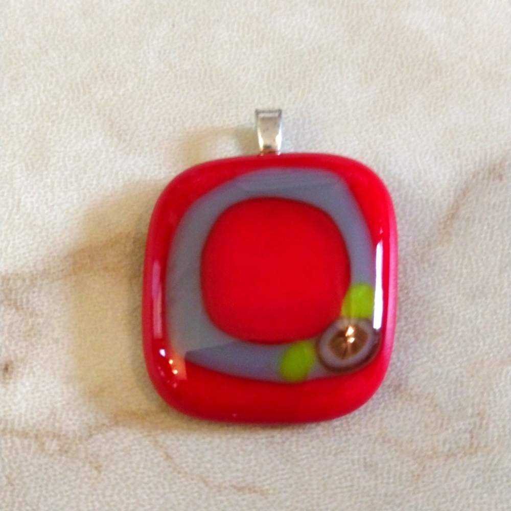 Ohio State buckeye glass pendant.